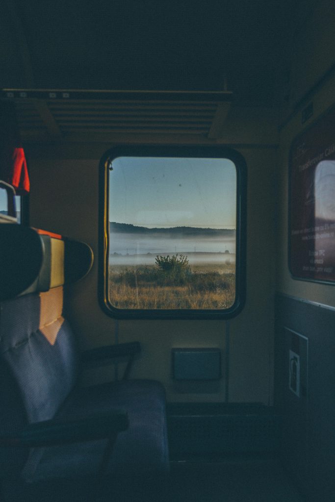 Interior view of a train with scenic landscape visible through the window in Cluj-Napoca, Romania.