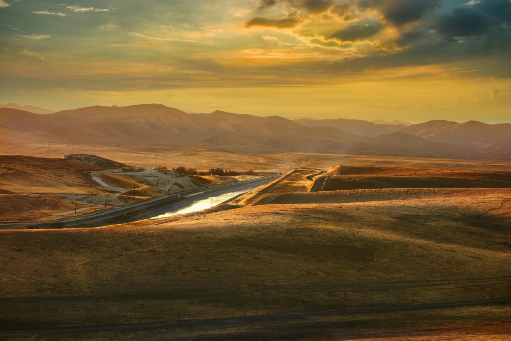 Scenic view of a vibrant sunset over the rolling hills of Merced, California, highlighting its natural beauty.